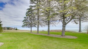 A grassy park area with several trees and a bench. - Waterfront Algoma Vacation Rental on Lake Michigan (Algoma)