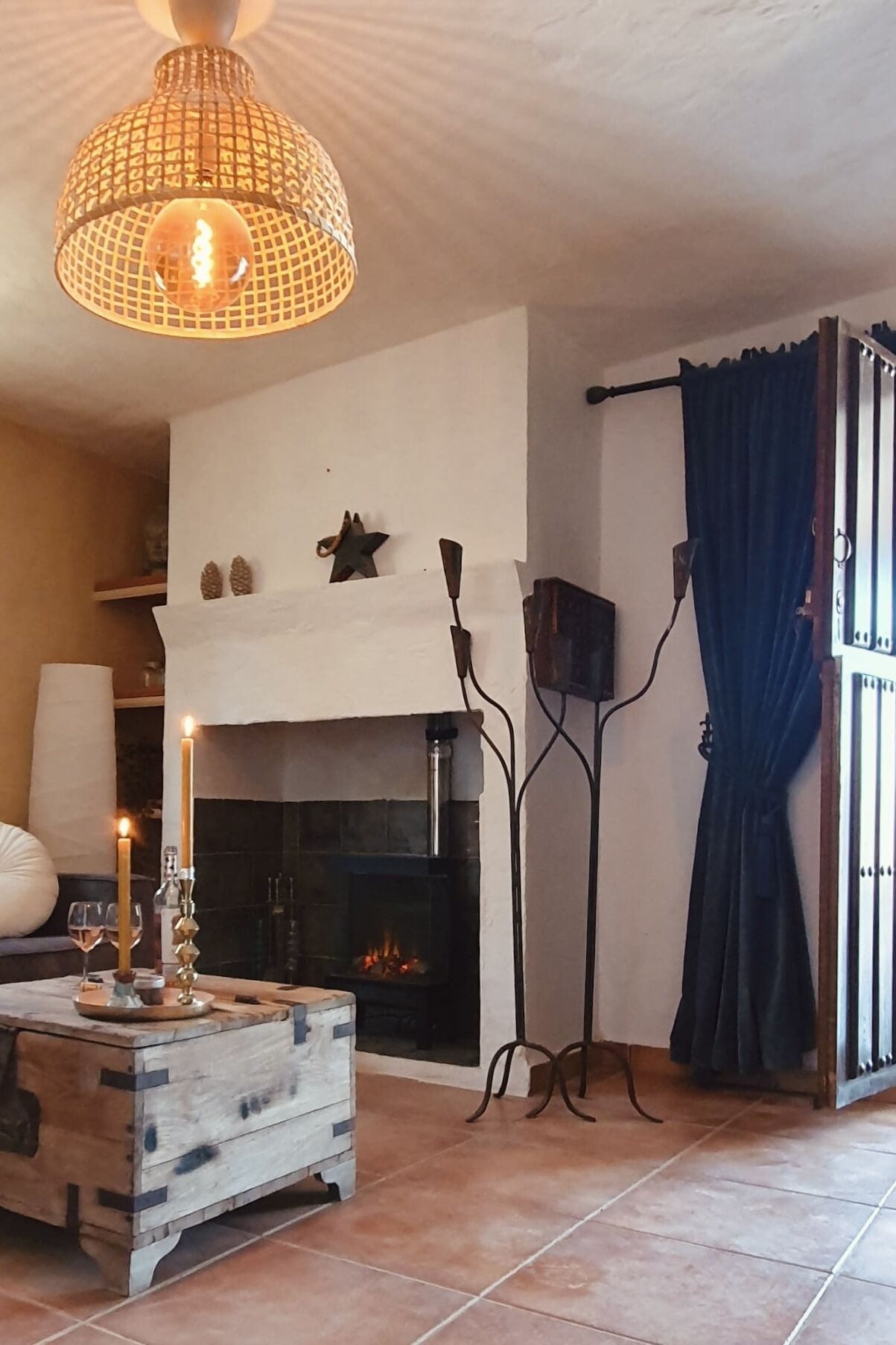 Una sala acogedora con chimenea, una mesa de centro de madera y una lámpara colgante.