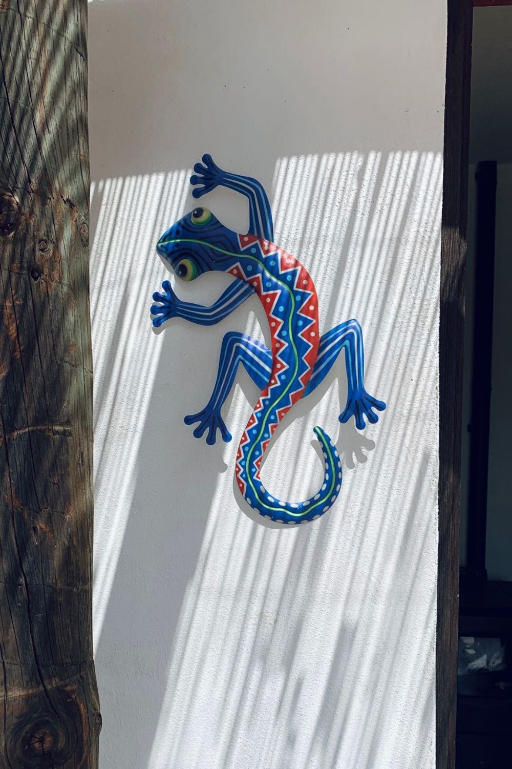 A decorative lizard sculpture on a textured wall.