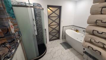 Een douche, een bubbelbad, handdoeken, zeep