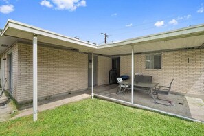 A single-story brick building with a covered patio area. - Spacious House w/ Jacuzzi Tub (Zachary)