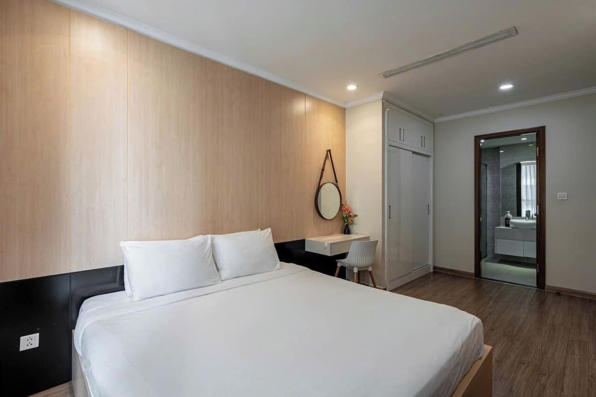 Ein Hotelzimmer mit Bett, Schreibtisch und Spiegel.