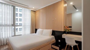 A modern bedroom with a large bed, a desk, and a chair.