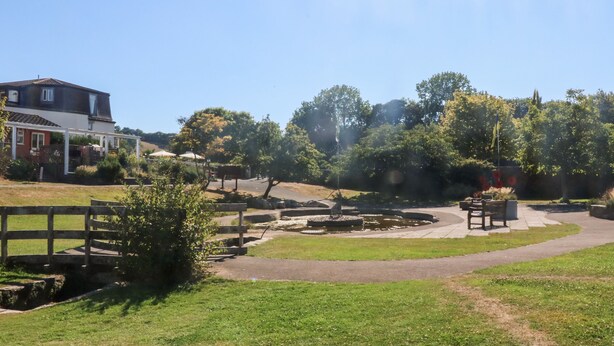A park with a pond, pathways, and a wooden fence. - West Island (Kingsbridge)
