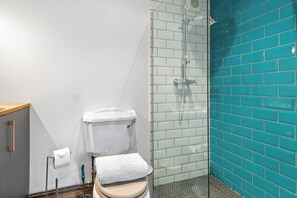 Une salle de bain avec des toilettes, une douche et un lavabo.