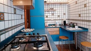 A kitchen with a gas stove, blue countertops, and tiled walls. - In the greenery of Rome, near Trastevere and the Vatican (Roma)