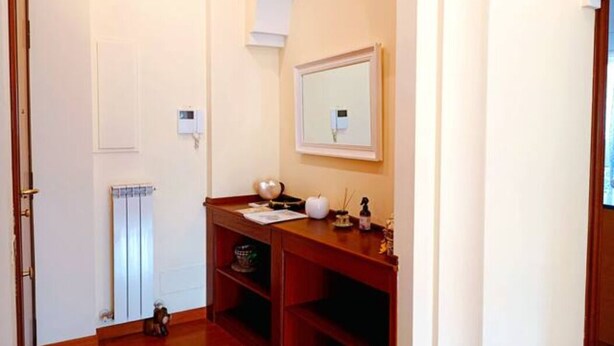 A hallway with a radiator, a wooden desk, and a mirror on the wall. - In the greenery of Rome, near Trastevere and the Vatican (Roma)