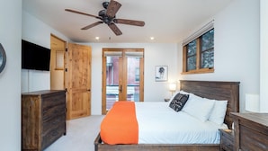 A bedroom with a bed, wooden furniture, a ceiling fan, a TV, and a window. - OwlMeadows16 3 Bedroom/3 Bath Condo (Telluride)