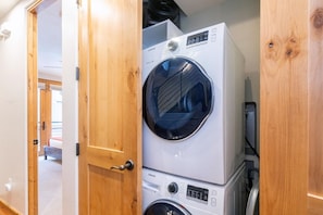 A laundry room with stacked washing machines and dryers.