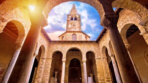 An ancient stone building with a central tower and arches.