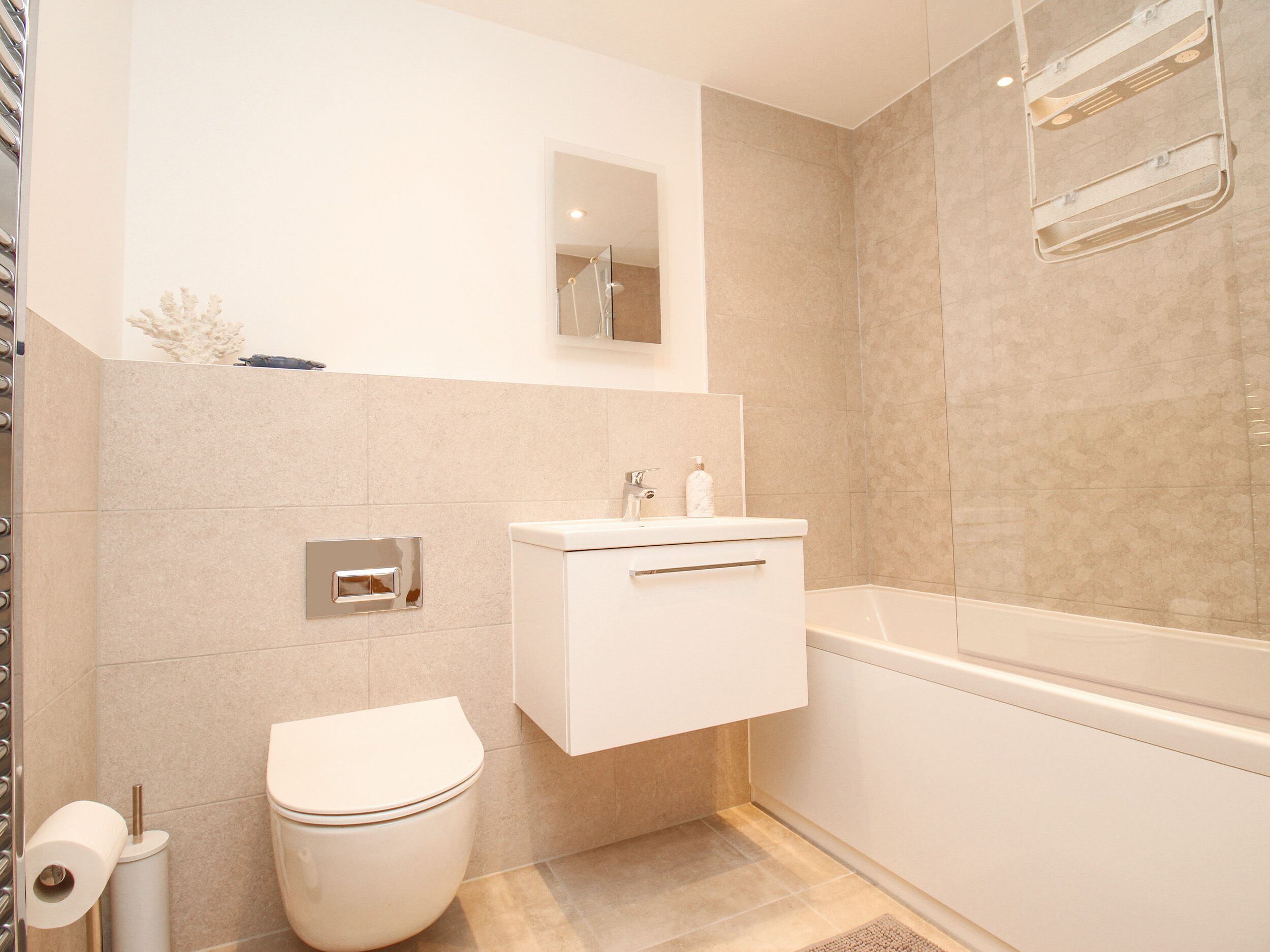 Un baño moderno con inodoro, lavamanos y bañera.