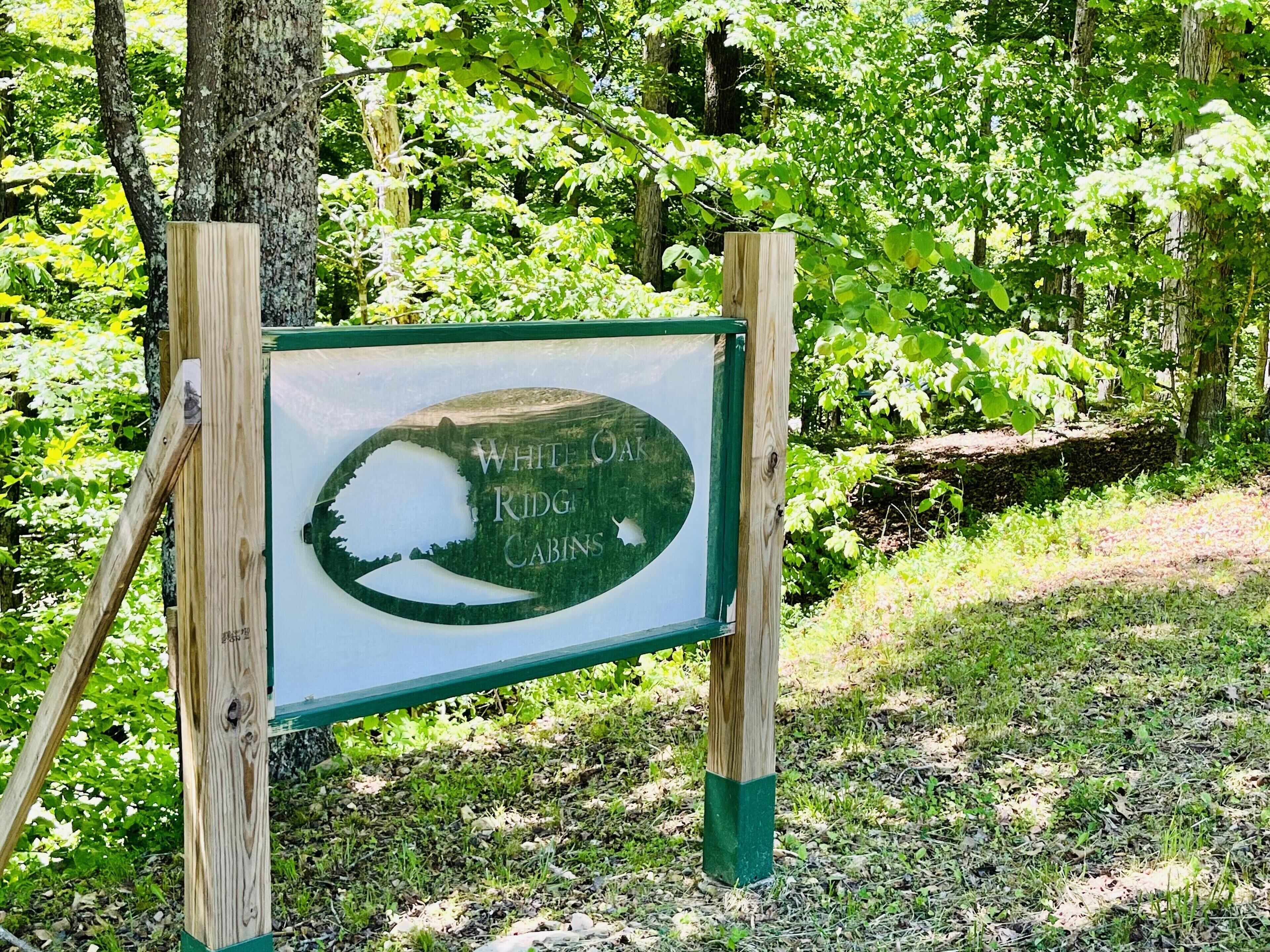 A sign for White Oak Ridge Cabins with a silhouette of a tree and cabin.