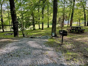 A campground with picnic tables, a gravel path, and a sign indicating a no parking zone. - Wilderness Retreat (Cadiz)
