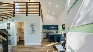 Eine moderne Küche mit blauen Schränken, einem Edelstahlkühlschrank und einer Bar mit Hockern.