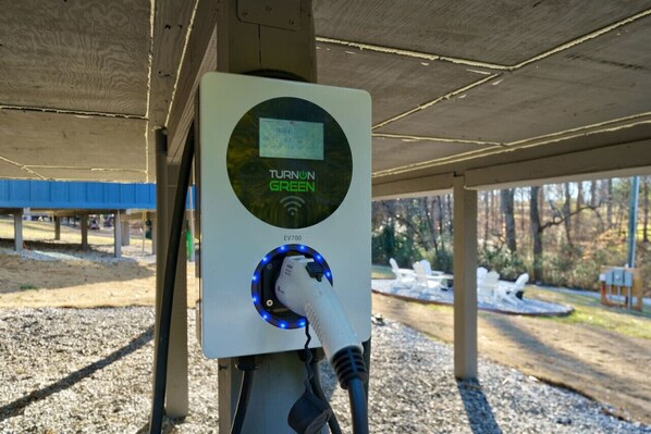 A charging station labeled "TURNON GREEN" with a digital display, connected to a vehicle. - Dahlonega Magnolia Tree Tiny Home *King Bed* (Dahlonega)