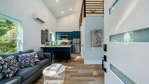 A modern kitchen with blue cabinets, a central island, and a stainless steel refrigerator.