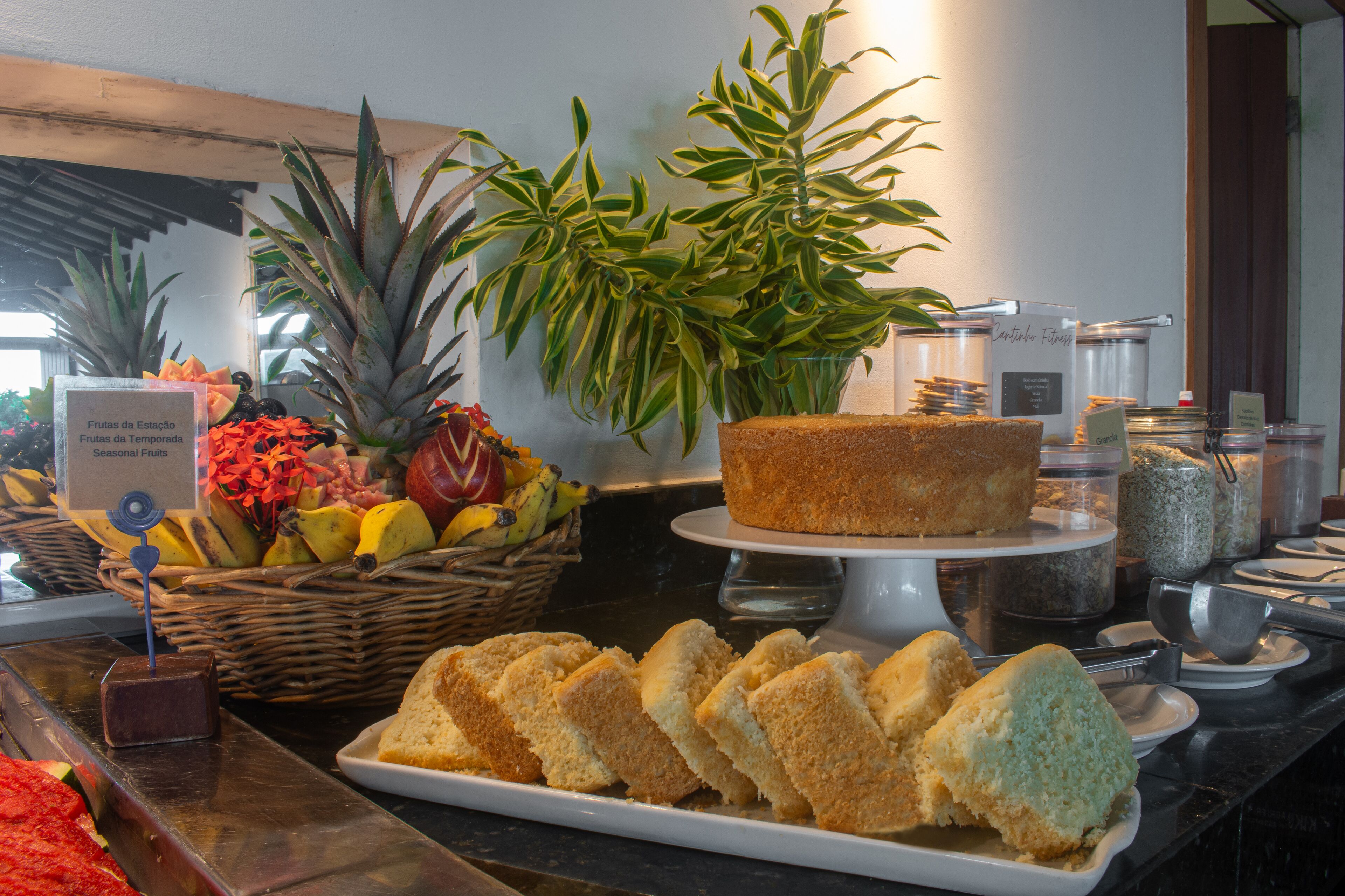 Un buffet proposant une variété de plats, notamment du pain, des fruits et un gâteau.