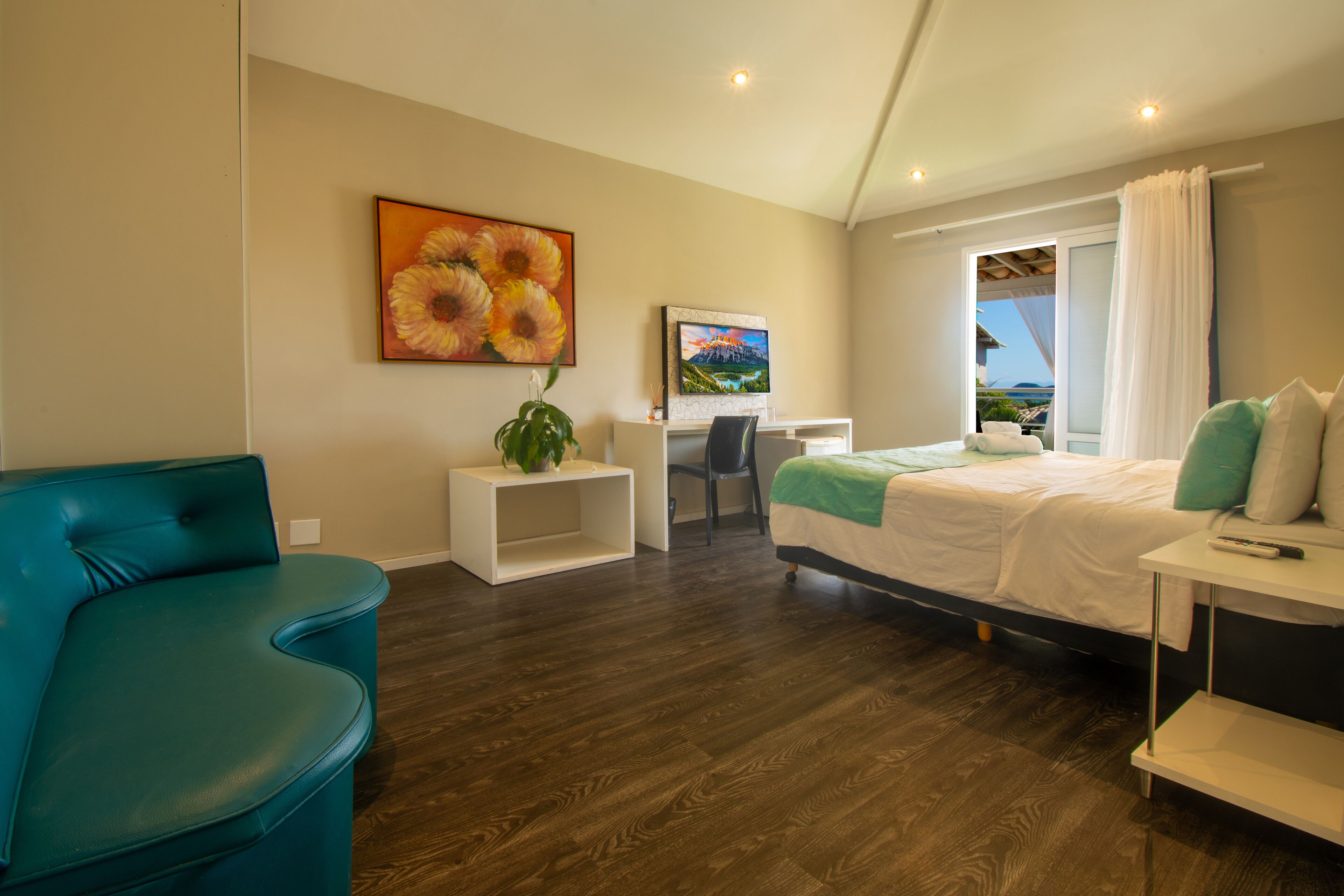 Una habitación de hotel moderna con una cama, un escritorio, una silla y un sofá azul.