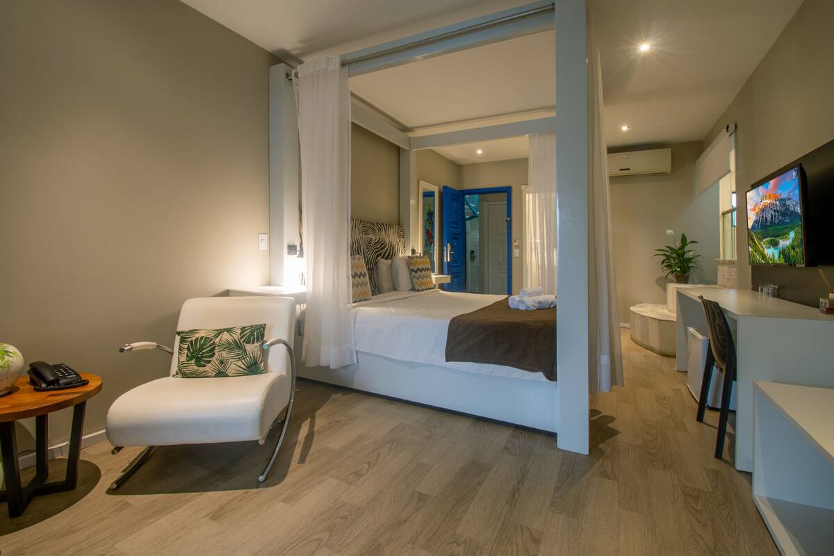Une chambre d’hôtel moderne équipée d’un lit, d’un bureau, d’une chaise et d’un téléviseur.