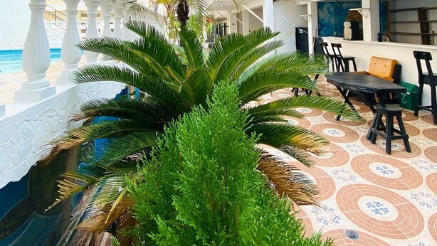 A courtyard with a pool, outdoor seating, and a mural. - Hotel cabañas de TOLÚ  (Sucre)