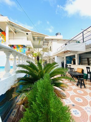 A courtyard with a pool, outdoor seating, and a mural.