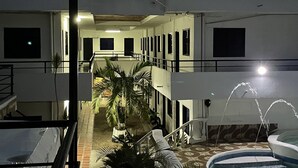 A multi-story hotel with a central courtyard, outdoor seating area, and a fountain. - Hotel cabañas de TOLÚ  (Sucre)