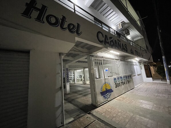A hotel entrance with a metal gate and a sign that reads "Hotel CABANAS de Tolu".