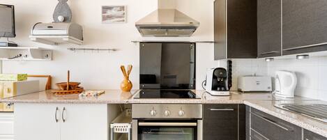 A modern kitchen with a built-in oven, a coffee maker, and a toaster.