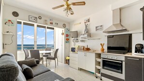 A modern kitchen with an oven, microwave, and a large window overlooking the sea. - WELCS APARTAMENTO 053 EMP  Frente al Mar (Empuriabrava)