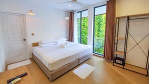Une chambre à coucher avec un lit, un ventilateur de plafond, une armoire et une fenêtre avec des rideaux.