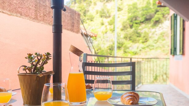 Una mesa de desayuno con croissants, zumo de naranja y una botella de jugo.
