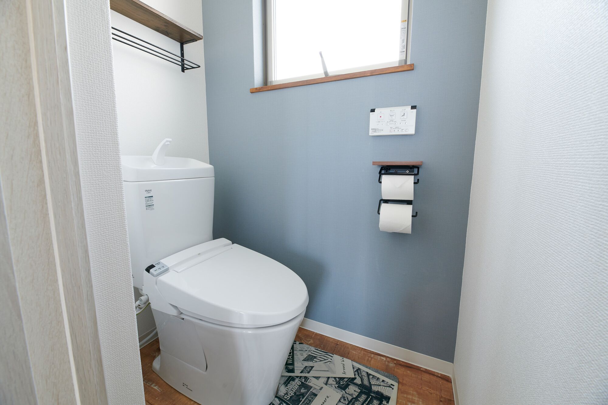 A small bathroom with a toilet, a sink, and a window.
