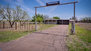 A rural entrance with a sign reading "WOODARD RANCH." - Stargaze, Hike & Kayak: Cabin Near Copper Breaks! (Crowell)