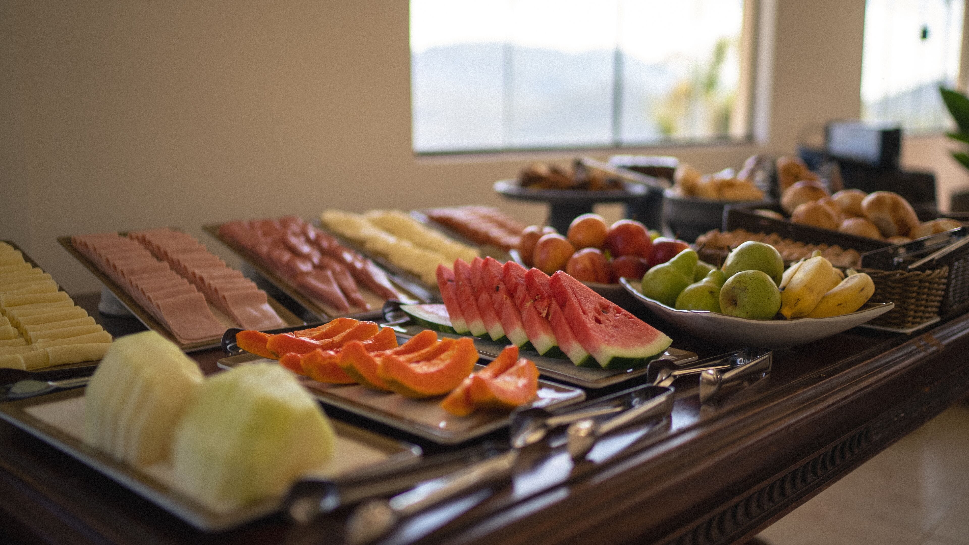 A buffet with various fruits and pastries.