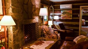 A cozy cabin interior with a stone fireplace, leather furniture, and a rustic decor. - Hikers Retreat in the Linville Gorge Forest (Nebo)