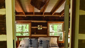 A cozy cabin bedroom with a bed, pillows, and a window. - Hikers Retreat in the Linville Gorge Forest (Nebo)