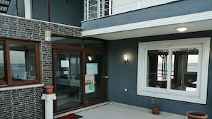 A building with a balcony, a glass door entrance, and a window with a view. - Melita Hotel (Urla)