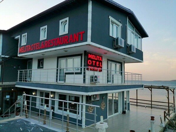 A two-story hotel with a balcony and a sign that reads "Melita Hotel & Restaurant". - Melita Hotel (Urla)