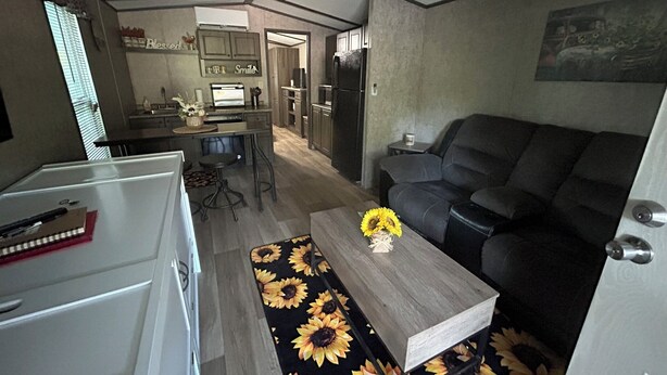 Ein kompakter Wohnbereich mit Küchenzeile, Essbereich und Sitzecke mit Sofa und Couchtisch.
