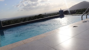 En swimmingpool med utsikt över ett berg och en klar himmel.
