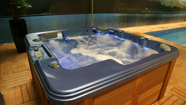 A hot tub with a wooden deck and a view of a lake. - Quinta do Passal (Pacos De Ferreira)