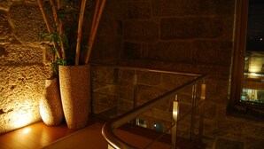 A stone wall with a potted plant and bamboo sticks. - Quinta do Passal (Pacos De Ferreira)