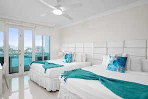 A hotel room with two beds, a ceiling fan, and a view of the city. - Panoramic Lagoon Studio + Resort Pool (San Juan)