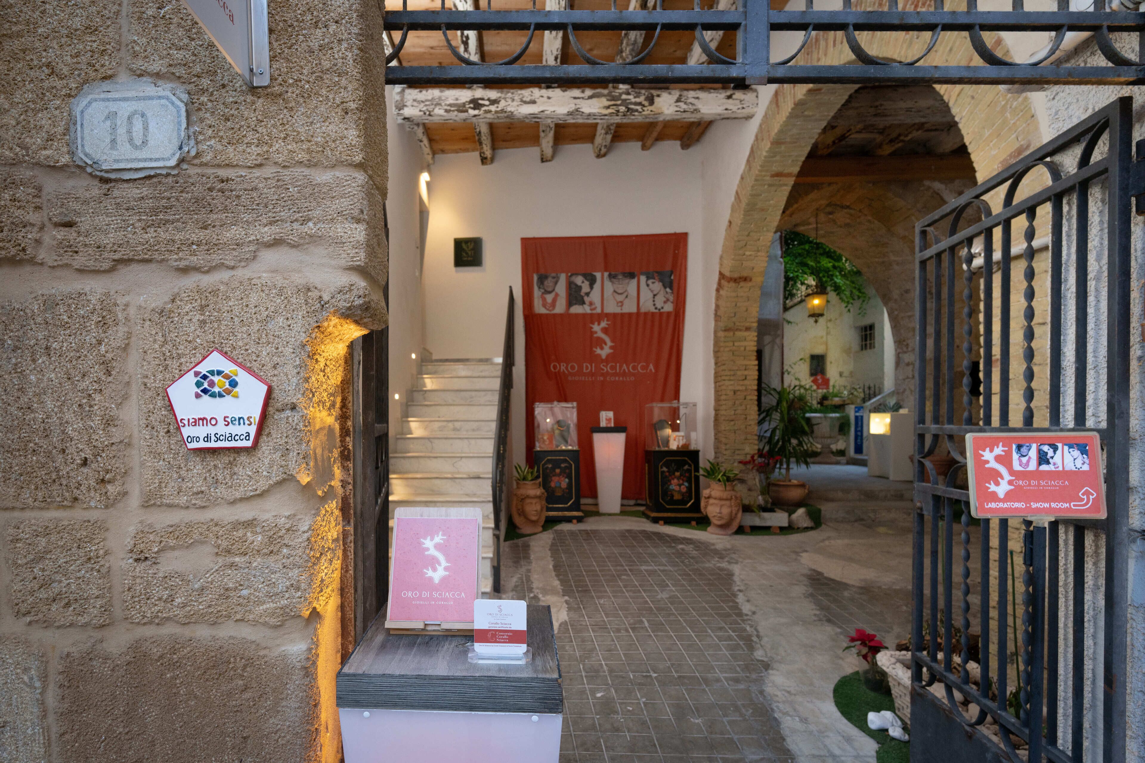 Une entrée en pierre menant à un bâtiment, avec une enseigne indiquant un laboratoire et une salle d’exposition.