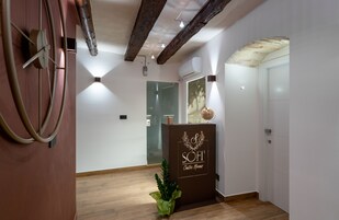 Un'area reception con pavimento in legno, una scrivania e una porta in vetro che dà su una stanza.