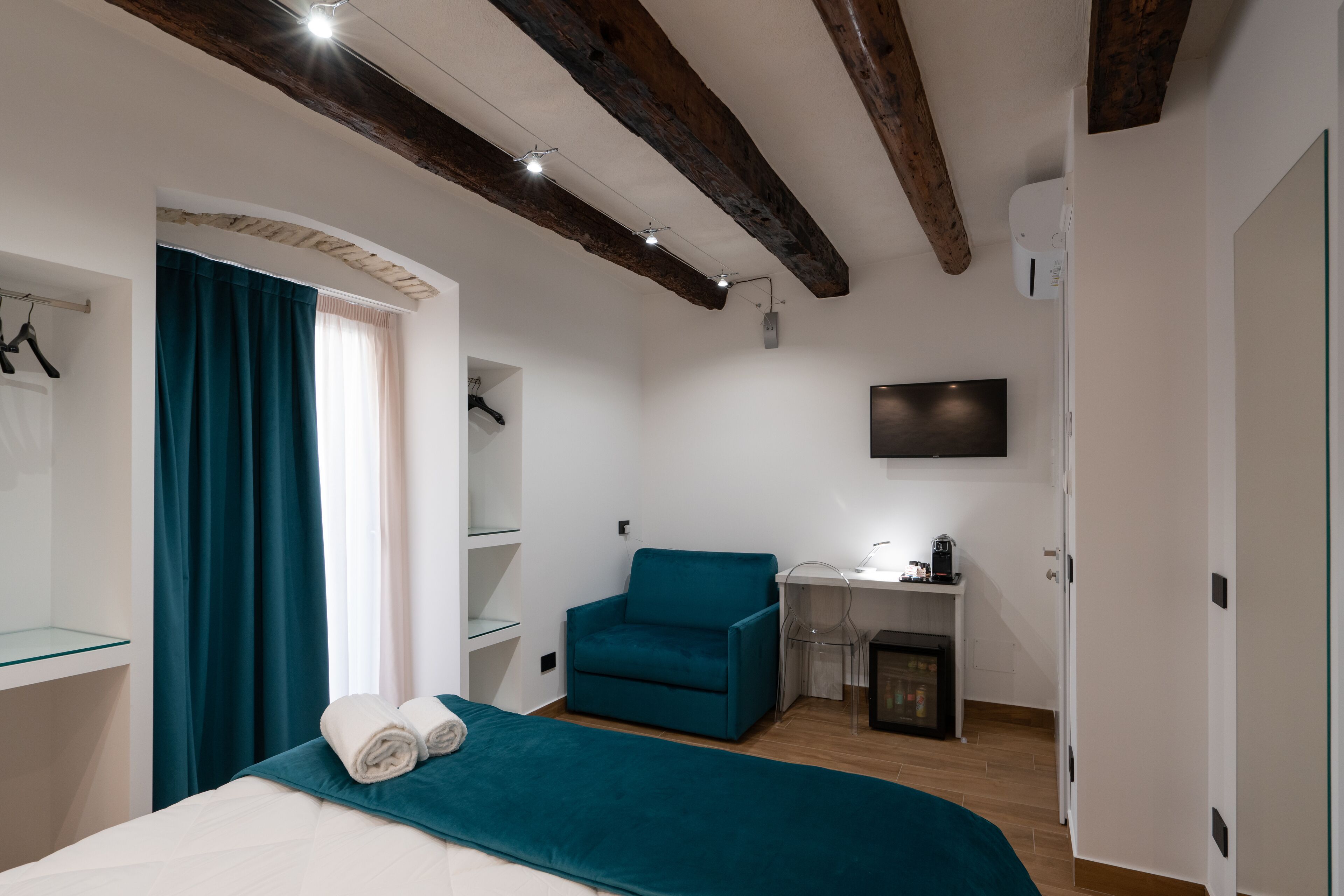 Une chambre à coucher avec un lit, une chaise, un bureau et un téléviseur.