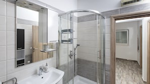 A modern bathroom with a glass-enclosed shower, a white sink, and a large mirror. - Apartment Mia - Two Bedroom Apartment with Balcony (Split)