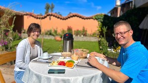 Een tafel buiten gedekt met eten en een thermoskan.