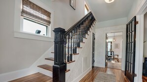 A staircase with dark balusters and wooden steps leading to a landing. - Hawthorn House Remodeled 3BR Walk to Town! (Colonial Beach)