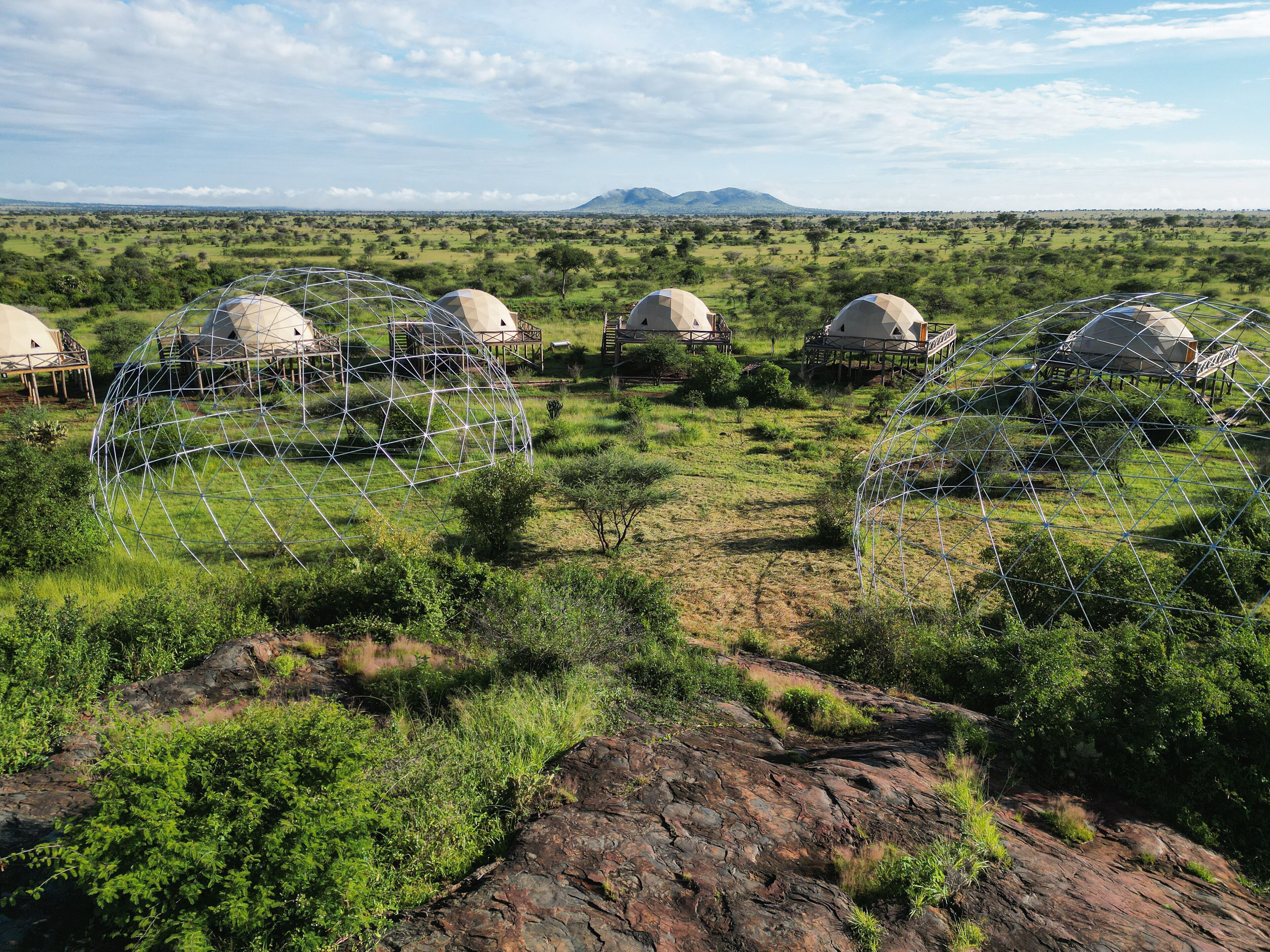 A series of dome-shaped structures in a natural landscape with a clear sky.
